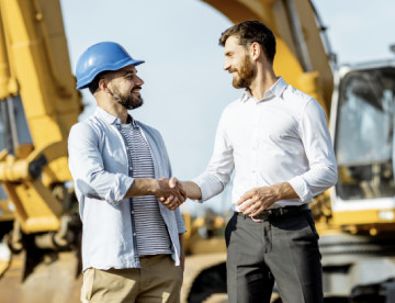 a dealer rep and equipment operator shaking hands