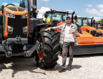 equipment operator standing next to tractor