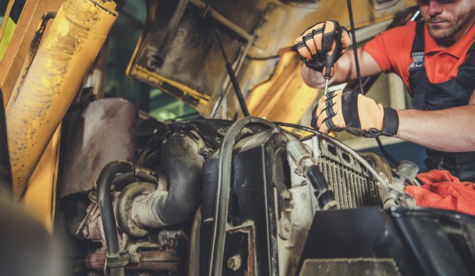 Heavy equipment technician working on a machine